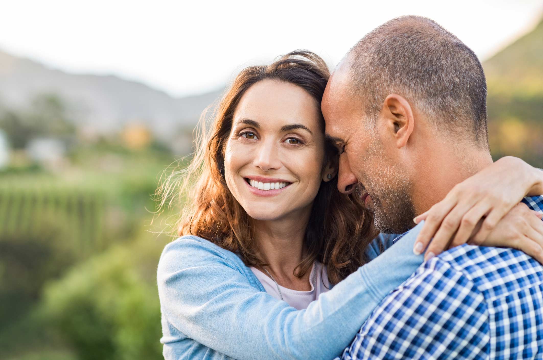 juvederm atlanta, image of a young woman smiling and embracing a man around the shoulders.
