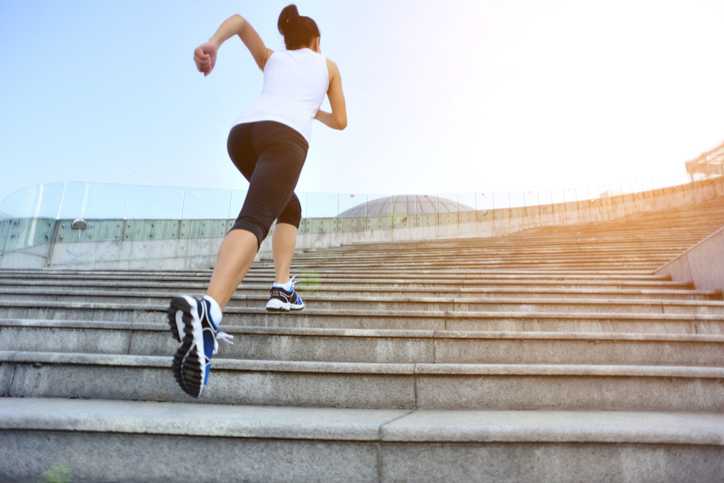 atlanta ankle and foot, woman in white shirt and jogging capris running up a large set of concrete stairs