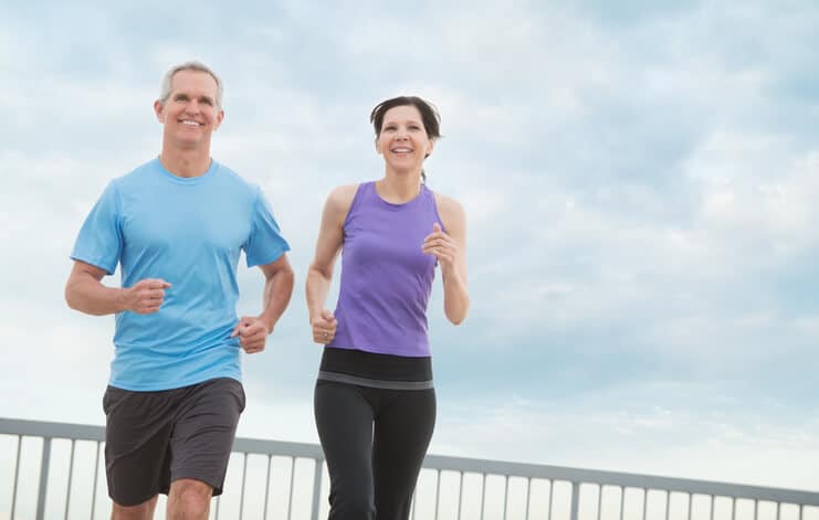 spinal stenosis treatment, image of middle aged man and woman happily jogging side by side.