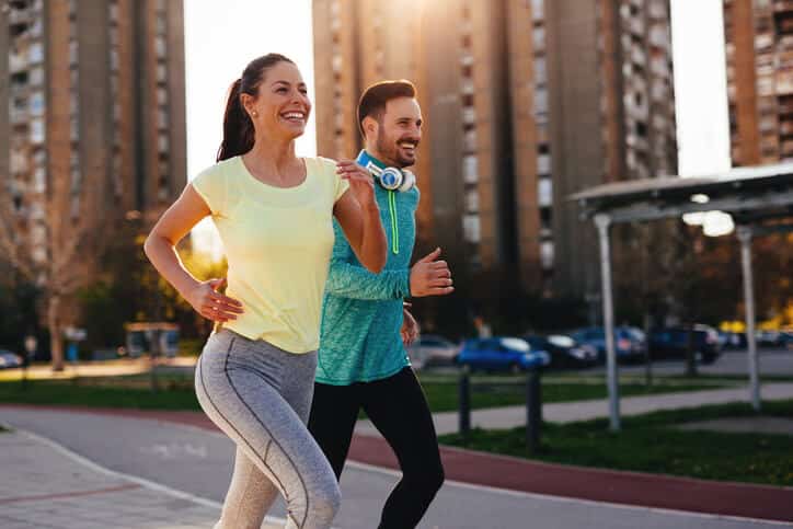 Prolozone Therapy, Man and woman couple wearing athletic clothing jogging side by side with smiles on their faces