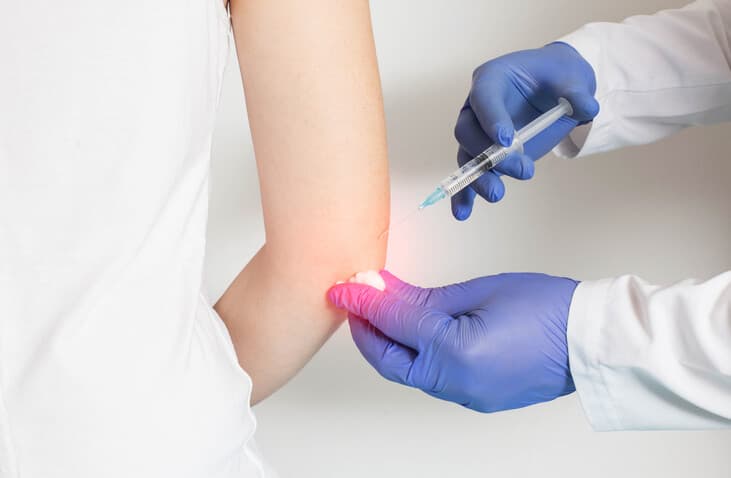 HemOzone Therapy, Medical practitioner injecting needle into woman's elbow