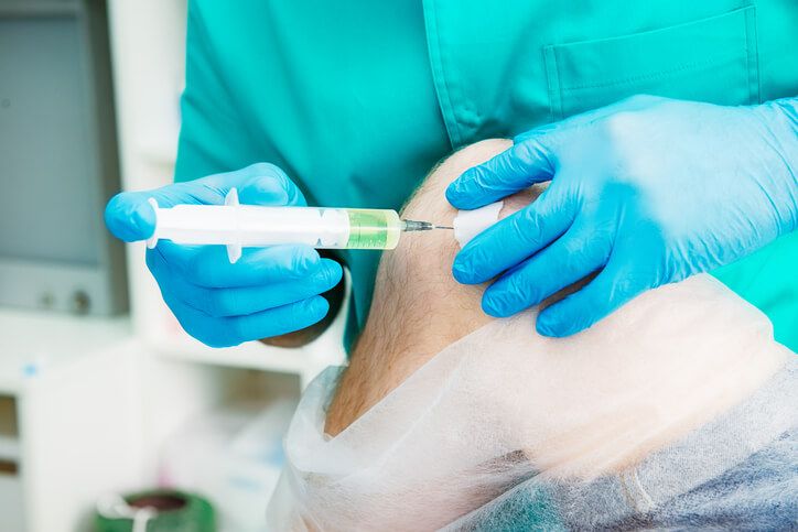 HemOzone Therapy, Medical practitioner injecting needle into patient's knee