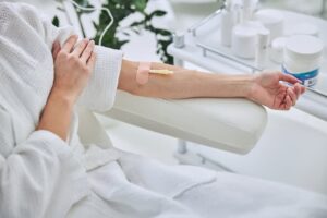 ozone therapy benefits, Woman wearing a white robe sitting in a reclining chair has an IV inserted into her left arm, receiving ozone therapy benefits.