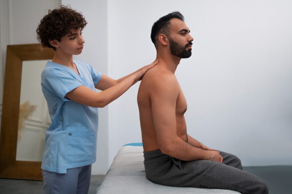 Cervical instability; image of a female nurse inspecting a male patient’s upper back using both of her hands.