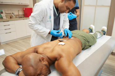 Image of a doctor inserting a needle into a patient’s back.