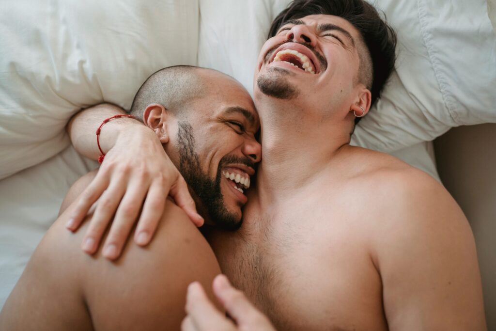 what is the latest treatment for erectile dysfunction, Image of a happy gay couple in bed together, embracing.