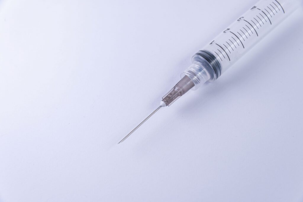 cortisone shot didn't work, Image of an injection needle on a white surface.