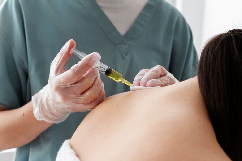 cortisone shot didn't work, Image of a male nurse inserting an injection into a female patient’s left shoulder.