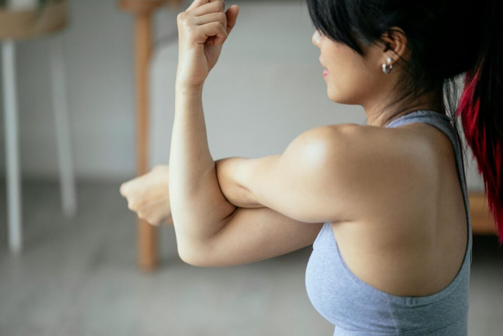 cortisone shot didn't work, Image of a woman wearing a gray tanktop doing an arm and shoulder stretch.