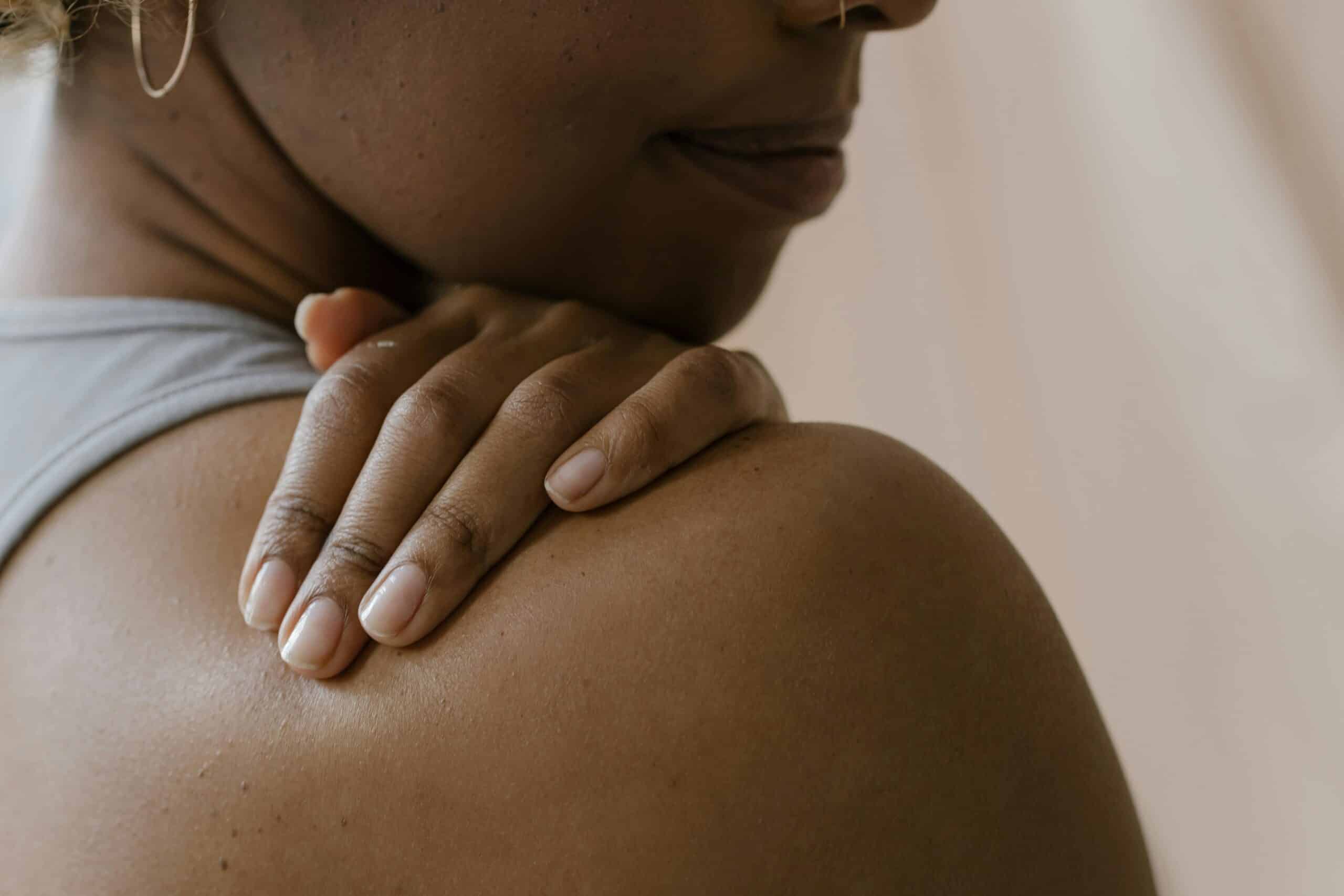 cortisone shot didn't work, Image of a woman holding her right shoulder with her left hand.