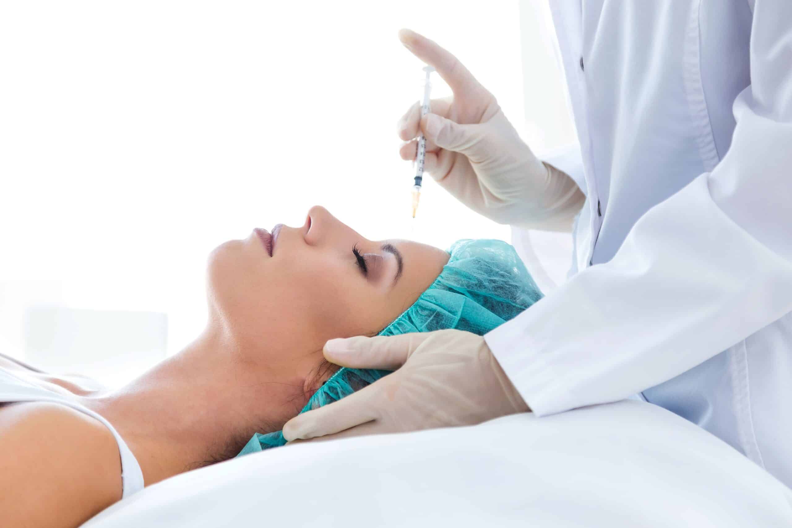 What is a Vampire Facial®, image of a doctor about to insert an injection into a young female patient’s forehead.
