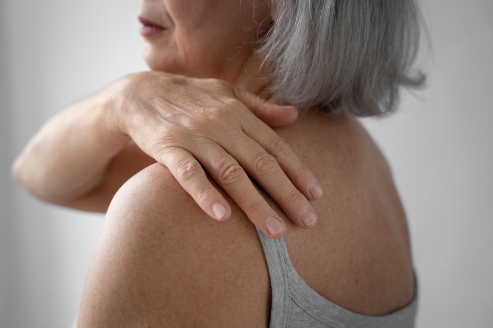 Regenexx Shoulder Treatment, image of woman holding her shoulder.